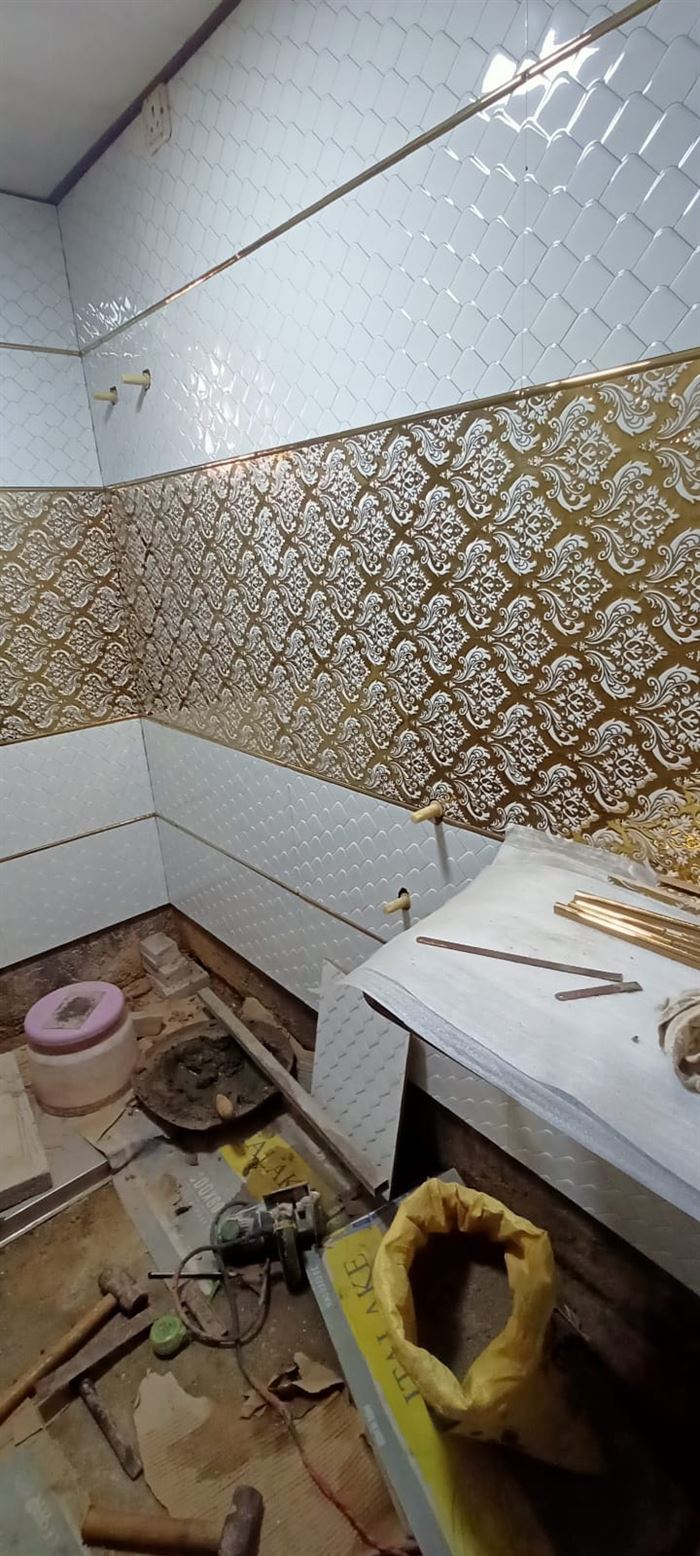 Bathroom finished in patterned gold and white tile