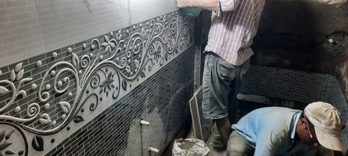 Tiled wall with decorative mosaic border