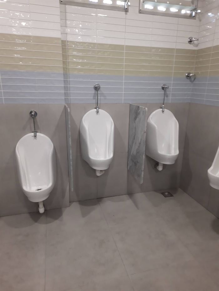 Completed commercial washroom with urinals and partitions